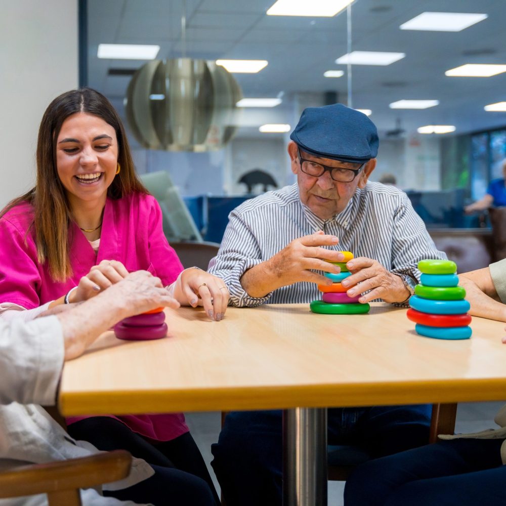 Nurse helping a elder woman playing skill games in a nursing home